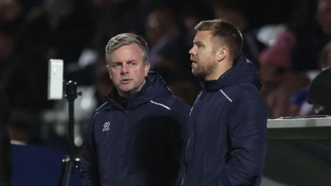 Elliot Dickman (left) alongside Nicky Featherstone in front of the dugout during Hartlepool's game with Yeovil