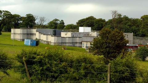 Kerelaw school viewed from behind a fence with shrubs in the foreground