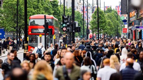 Busy scene on Oxford Street with people and buses