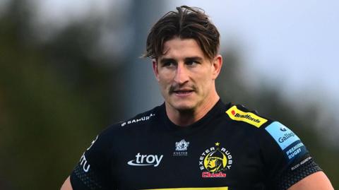 Tom Hendrickson stands with hands on hips during a pause in a game for Exeter