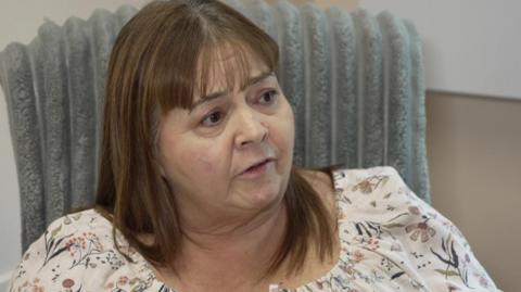 Image of Sonia sat in a grey chair.