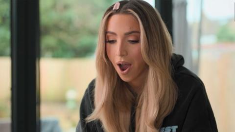 GK Barry sitting in the kitchen in a black hoodie