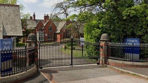 The Harris Park site showing a large red brick building in landscaped gardens behind a black cast iron fence and gate
