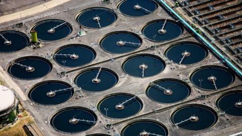 Aerial shot of Twenty water clarifiers continue the process of water purification at this Waste Water Treatment Plant near Camberley, Surrey