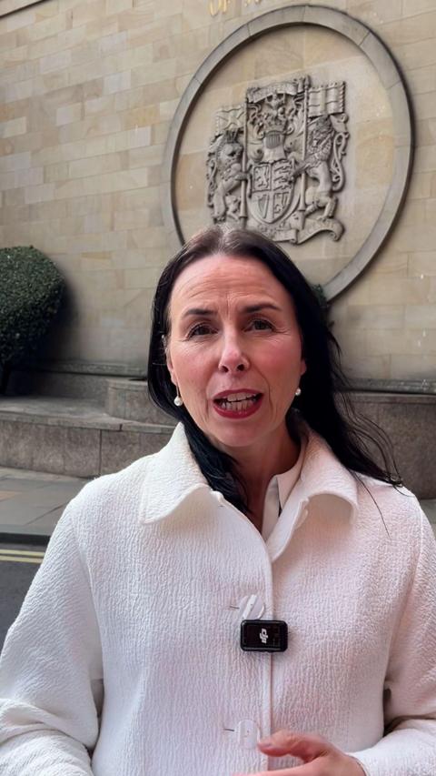 Reporter outside court eith black hair and white coat