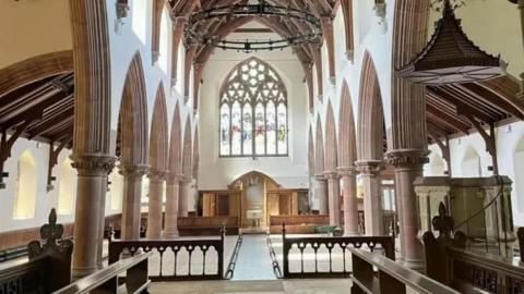 The interior of Cathedral Isle of Man after the removal of most of the pews for refurbishment works. The tall building has a large stained glass window above the alter.