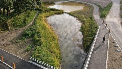 Aerial shot of Wild Park rainscape in Brighton showing wetlands and water and a path around it