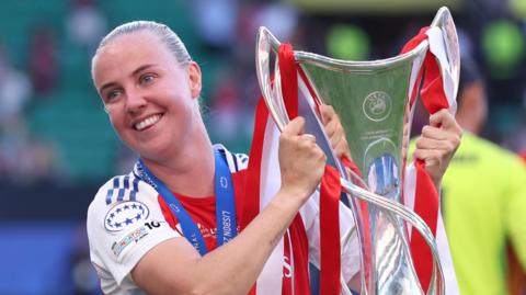 Arsenal forward Beth Mead holding the Women's Champions League trophy
