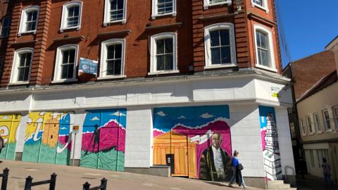 The outside of the former Tesco building on Guildhall Hill in Norwich city centre. The ground floor of the building is covered in colourful murals.