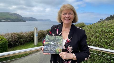 Susan Jellis holding a copy of the book