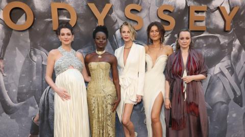 Anne Hathaway, Lupita Nyong'o, Charlize Theron, Zendaya and Samantha Morton standing in a row in designer outfits in front of a large sign saying "Odyssey" at the premiere in New York on 14 July 2026