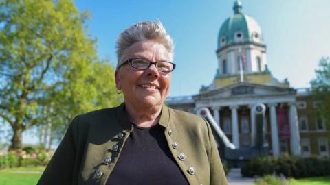 Woman smiles outside Imperial War Museum in London