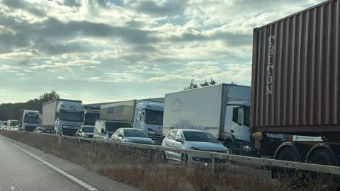 Traffic is queuing on one side of a motorway.