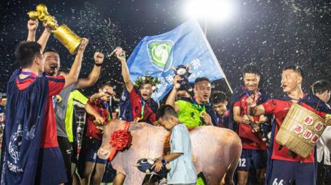 Chinese local football team celebrating tournament victory