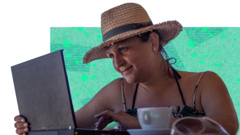 Woman speaks to phone in front of laptop
