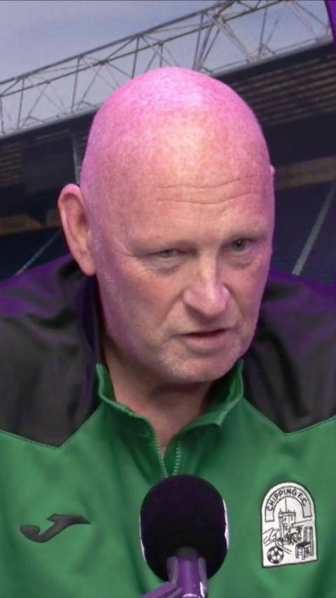 Man with green jacket and bald head 