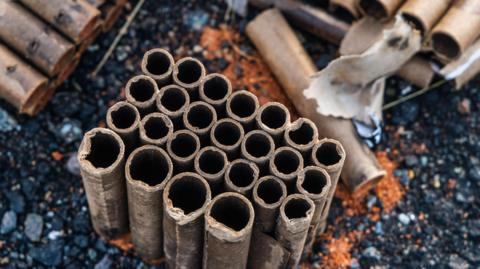 Empty firework cylinders on a pavement