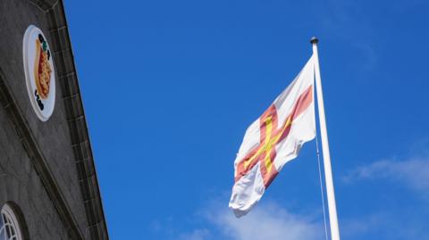 The front of the States of Guernsey building with a flag to the right.