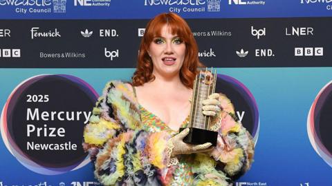 CMAT poses with her shortlist award as she arrives to the Mercury Prize awards in Newcastle