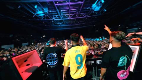 young guys DJing to a huge crowd in an arena