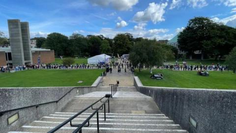 A shot of a steep exterior staircase with lawns at the bottom with people in the distance at the University of Sussex campus in Falmer