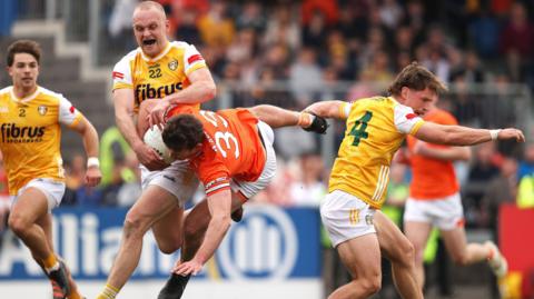 Ethan Rafferty takes a tumble after a challenge by Antrim's Kavan Keenan (right) during his stint outfield for Armagh following his return from a black card