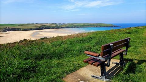 Blue sky, a beach and a bench