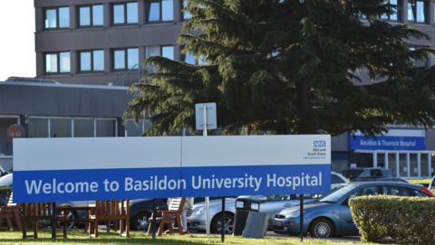 Exterior of Basildon Hospital showing name sign and buildings