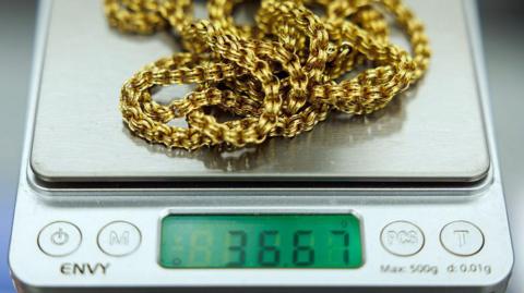 A close up of a gold chain on a set of scales in a jeweller in Hatton Gardens