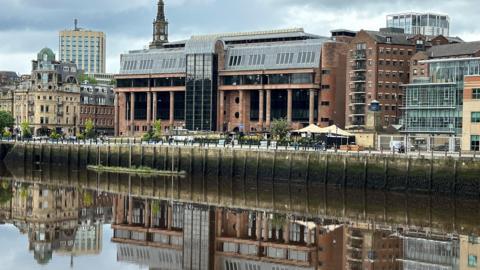 A court building reflected in a river.