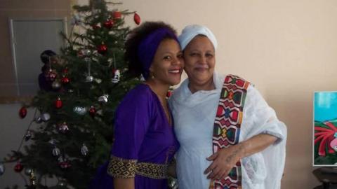 Tutu and her mother is posing in front of a Christmas tree.