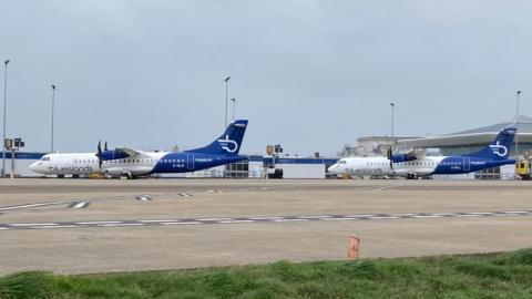 Two Blue Islands planes at Jersey Airport with the terminal building behind.