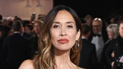 Myleene Klass looks straight on at the camera, she is wearing large gold hoop earrings and has her light brown wavy hair down