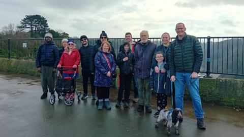 A group of people standing at a viewpoint on the Avon Gorge looking and smiling at the camera