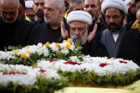 Lebanon's Hezbollah deputy leader Sheikh Naim Qassem, a man with a grey beard, closes his eyes and prays as he leads funeral prayers during the funeral of Hezbollah senior leader Ibrahim Aqil