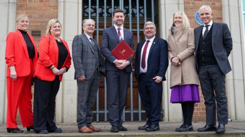 left to right: Jean Flaherty (deputy leader, Warrington Council), Karen Shore (deputy leader, Cheshire West and Chester Council), Hans Mundry (leader, Warrington Council), Jim McMahon, Nick Mannion (leader, Cheshire East Council), Louise Gittins (leader, Cheshire West and Chester Council), and Michael Gorman (deputy leader, Cheshire East Council)