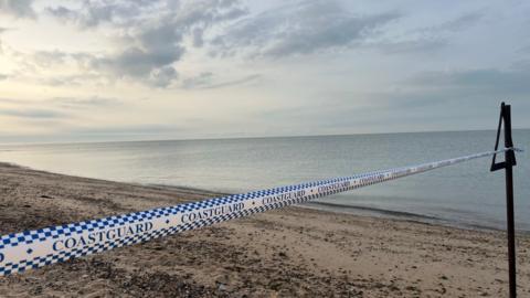 Coastguard tape on a beach.