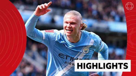 Erling Haaland of Manchester City smiles and celebrates his goal with one arm in the air 