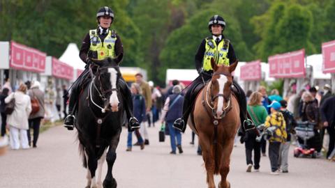 Mounted police make their way past shops during the Royal Windsor Horse Show
