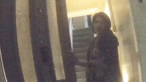 Woman opening a front door to a house