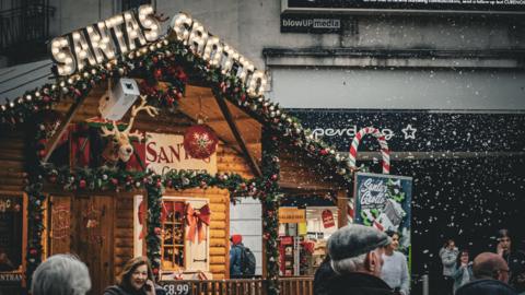 Santa's grotto on Queen Street is a traditional wooden chalet with festive bauble and a reindeer head as decorations.