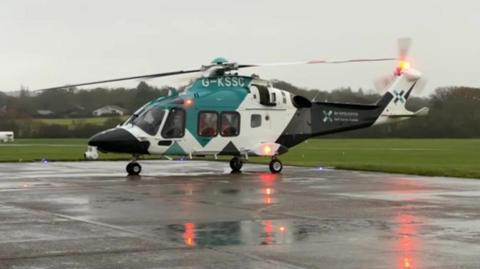 Helicopter, Air Ambulance Charity Kent Surrey Sussex, getting ready to take off from a runway in Surrey