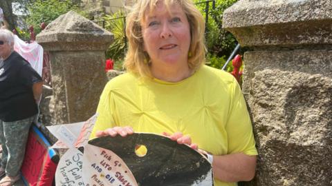 Ruth FitzJohn holding a sign at protest