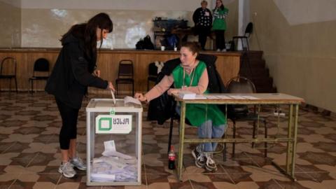 A voter casts her ballot at a polling station during parliamentary elections in the village of Napareuli in the region of Kakheti