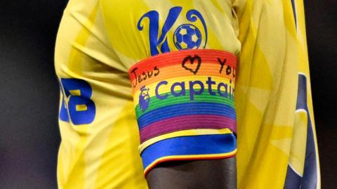 A close-up of Crystal Palace captain Marc Guehi's armband with its 'Jesus loves you' message