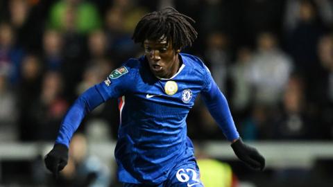 Shim Mheuka shapes his body to control the ball with his arms out