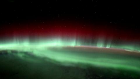Bright green lights with some red lights on top against a dark, starry sky