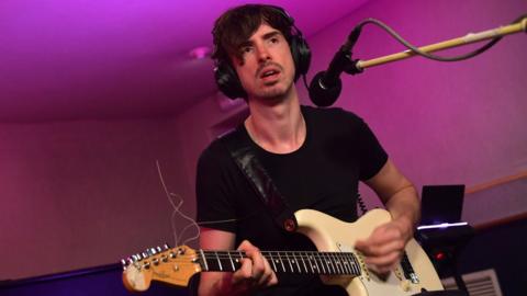 Dyn yn chwarae gitâr drydanol mewn cyngherdd