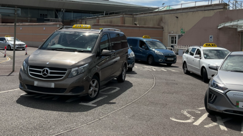 A series of taxis parked up ready to collect customers