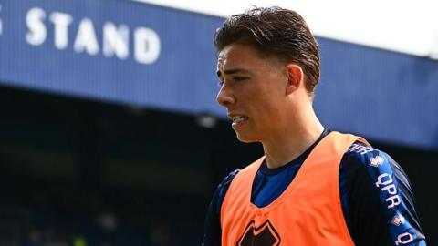Harrison Ashby wearing an orange bib and a training kit with 'QPR' written on the left shoulder 